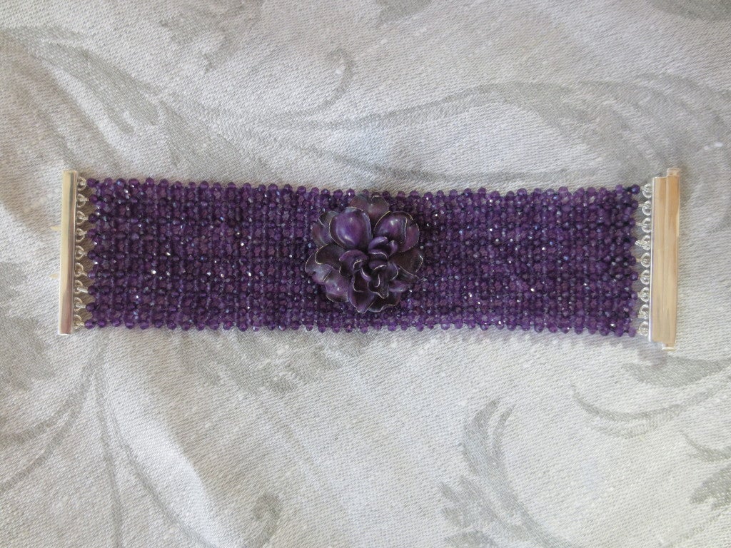 Intricately woven amethyst bracelet with secure sterling silver clasp is absolutely stunning. Measuring 1 3/4 inch wide, this bracelet is a conversation piece. Made of faceted amethyst beads measuring 1 mm each, this detailed woven bracelet fits