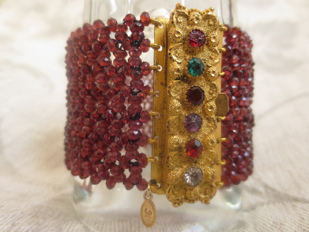 Intricately woven garnet bracelet with amazing mid 19th century clasp is absolutely stunning. Measuring 1 3/4 inch wide, this bracelet is a conversation piece. Made of faceted garnet beads measuring 1 mm each, this detailed woven bracelet fits very