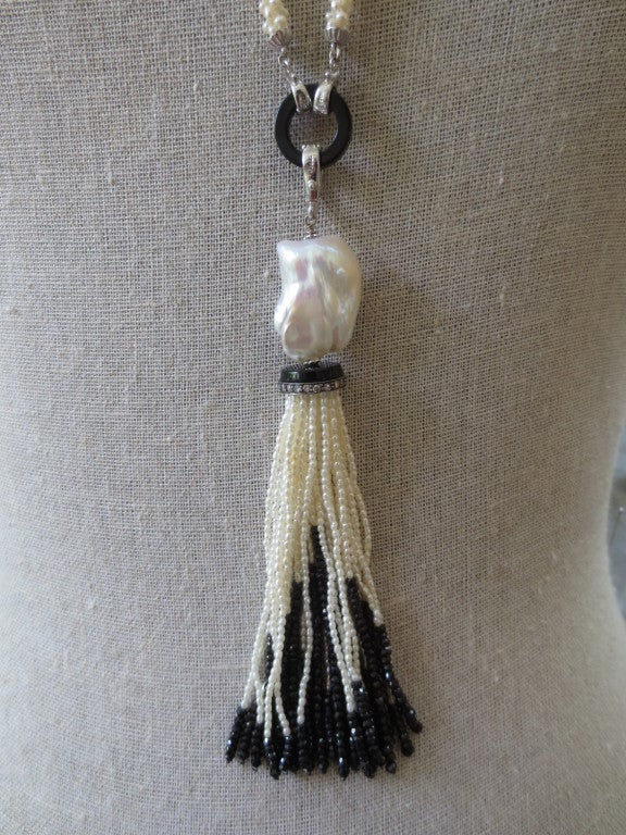 Gorgeous tassel is made of pearls and onyx. Strands made of fine white cultured pearls and faceted onyx beads drape from the diamond encrusted silver and onyx rondelle. Woven round, not twisted strands.Tassel measures approximately 4.25