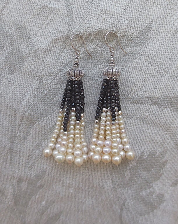 This beautiful pair of tassel earrings is composed of diamond encrusted sterling silver cups and finished with gorgeous, slightly graduated strands of pearl, faceted onyx and sterling silver beads. Ear wire is 14k white gold.