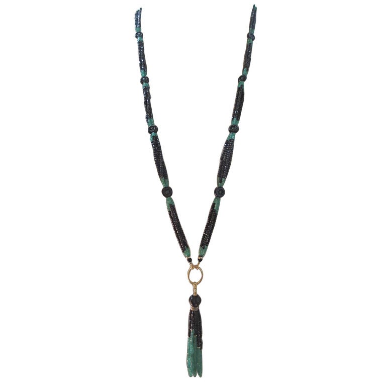 This art deco inspired tassel sautoir is composed of glittering faceted black spinel and emerald beaded sections.  The sautoir necklace is finished with an elegant tassel made of a lovely carved onyx bead, 14k yellow gold, sterling silver and