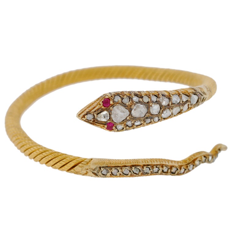 A spectacular contemporary diamond and ruby snake bracelet! With a wonderful Victorian look, this piece is made of 22kt yellow gold and portrays the coiled body of a charming snake. The body of the snake consists of thick twisted gold and has a