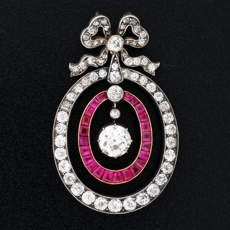 An absolutely fabulous diamond and ruby encrusted pendant from the early Victorian (ca1850) period! This gorgeous piece portrays 2 sparkling hoops with a lovely bow resting on top. The pendant, which is particularly large in size, is made of 18kt