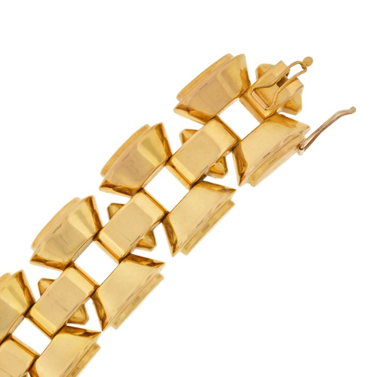 A beautiful heavy gold link bracelet from the Retro (ca1940) era! The bracelet, which is absolutely striking when worn, is made of vibrant 18kt yellow gold, and comprised of 3 rows of tire track links. The 2 outer rows are made up of links that