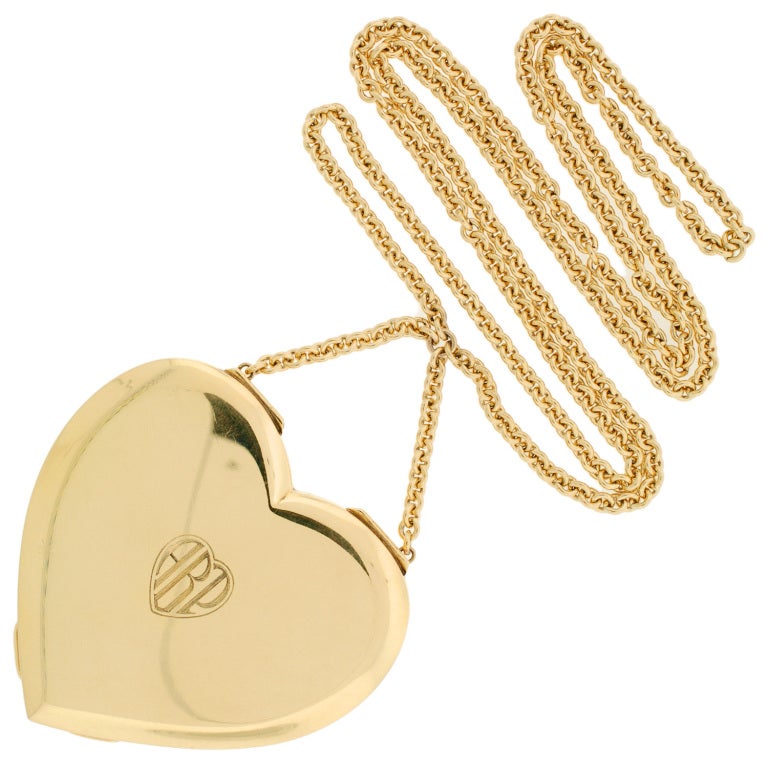 A fabulous Tiffany compact locket from the Retro (ca1940) era! This striking necklace features a compilation of a 1940's 14kt gold compact which has been attached to a modern gold filled chain. The heart is particularly large in size and the chain