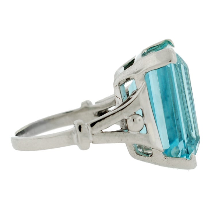 A fantastic Retro aquamarine cocktail ring from the 1940s! The ring, which is made of 14kt white gold, holds a large Emerald Cut aquamarine stone at its center. The aqua stone, which is prong set, weighs approximately 12ct+ and has a gorgeous sky
