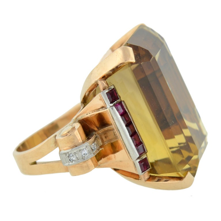 An striking cocktail style citrine ring from the Retro (ca1940) era! Made of 14kt yellow gold, this impressive ring features a Step Cut citrine stone, which is particularly large in size, at its center. The citrine, which is held in a 4 prong