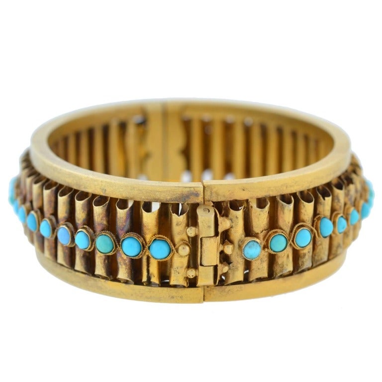 An exquisite gold and turquoise bracelet from the Victorian (ca1880) period! This wonderful hinged bangle is made of 15kt yellow gold and is decorated with 39 Persian turquoise stones. Each stone is bezel set and surrounded by a thin gold rope wire