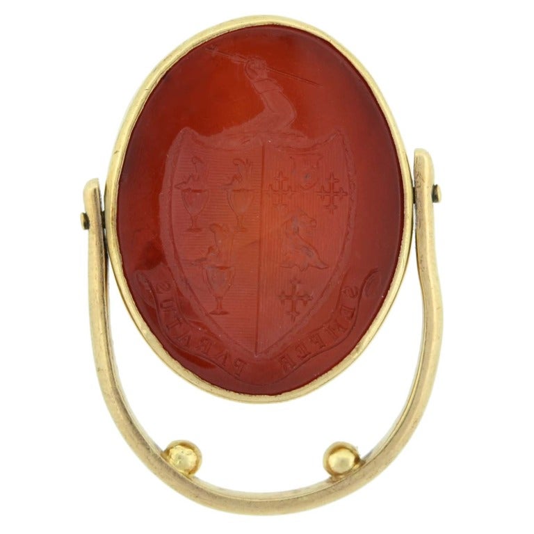 A very unique and interesting flip ring from the Victorian (ca1880) era! Made of 14kt yellow gold, the ring features a double-sided carnelian intaglio held within a gold bezel. The design of the ring allows the oval shaped carnelian center to flip,