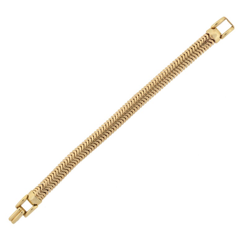 A fabulous Retro (ca1940) gold bracelet from Tiffany & Co.! This unique piece is made of 14kt yellow gold and has a flexible snake chain design. At each end of the piece is an open buckle and a hinged clasp hooks the two ends securely together. The