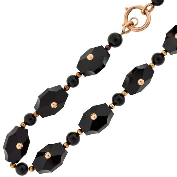 A wonderful onyx link necklace from the Victorian (ca1880) era! This fantastic piece is comprised of 14 hand carved onyx links which have a striking elongated octagonal shape. The links have faceted faces and a small 15kt rosy yellow gold bead set