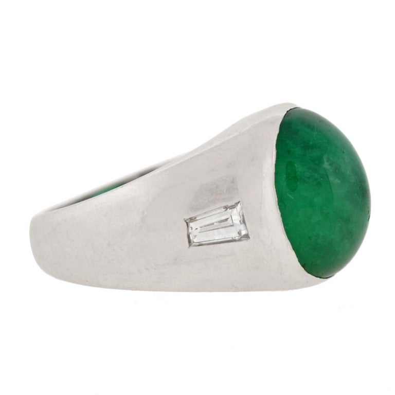An absolutely phenomenal emerald and diamond ring from the Retro (ca1950) era! The ring, which is made of platinum, has a natural cabochon emerald set within it. The stone, which is oval in shape, has exquisite, luscious green color and a total