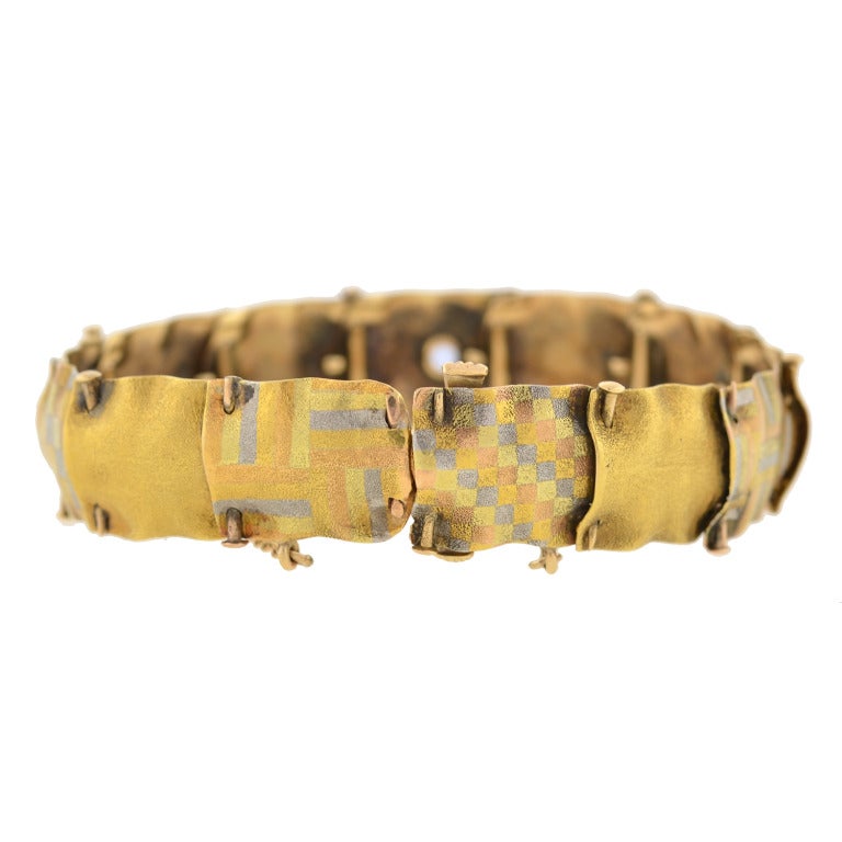 A beautiful mixed metals bracelet from the Edwardian (ca1910) era! This striking piece is from renowned Newark maker A.J. Hedges & Co. and is comprised of 13 links made of 14kt gold and platinum. The links have a fabric-like appearance with pierced