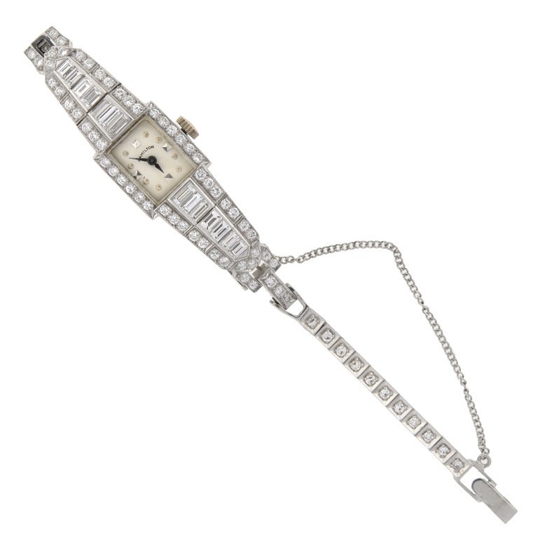 A fabulous platinum and diamond Hamilton lady's bracelet watch from the 1950s. This gorgeous watch has a square dial surrounded by sparkling diamonds. The silvered dial has square and circular indexes. Five platinum hinged links sprout from the top