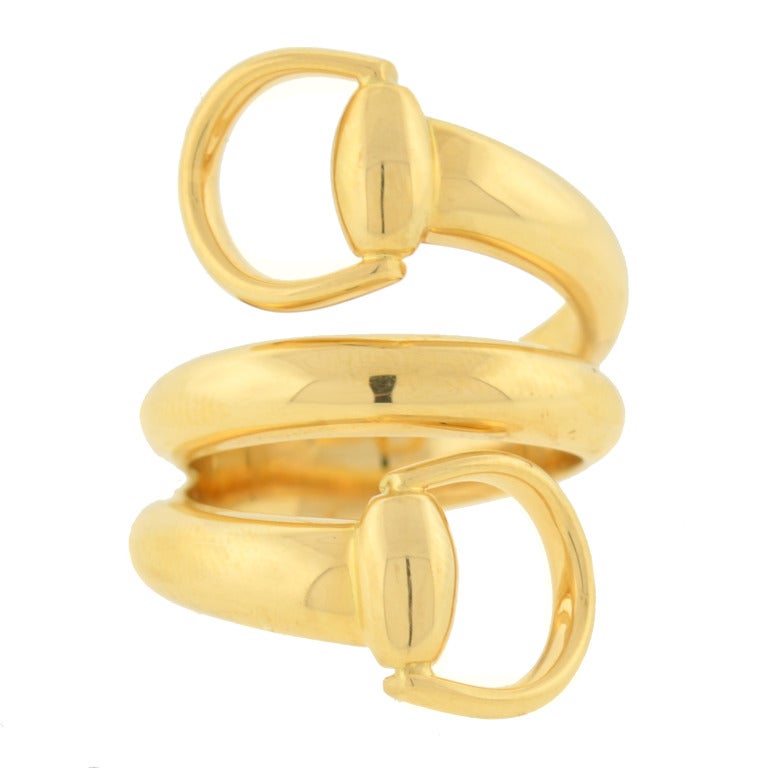 A fabulous signed Estate Gucci ring! This fashionable ring has a very attractive equestrian-inspired design, which looks striking when worn. Made of vibrant 18kt yellow gold, it resembles a smooth triple wire band that wraps around your finger and