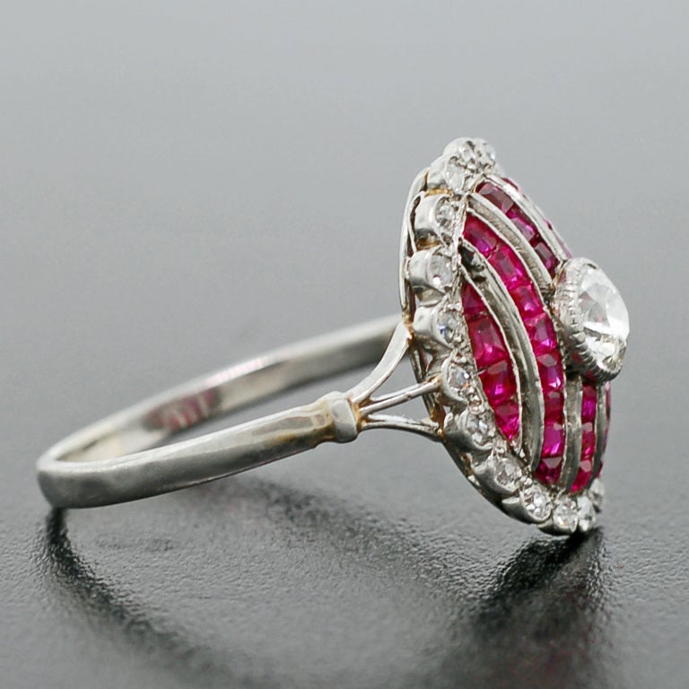A stunning diamond and ruby ring from the Edwardian (ca1910) era! This gorgeous ring is made of platinum topped 14kt yellow gold and has a stunning old Mine Cut diamond bezel set in its center. The center diamond is set atop a bed of 6 graduating