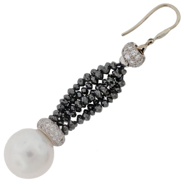 Absolutely wonderful pearl and diamond Estate earrings! Each of these lovely earrings is made of 18kt white gold and comprised of diamond encrusted beads that connect together by strands of black diamond beads. There are a total of 6 strands of