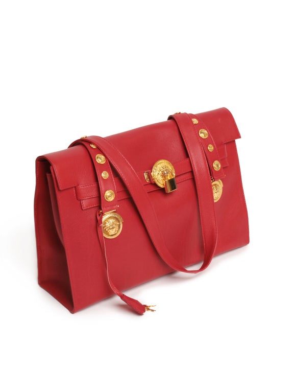 Prepare to carry high fashion on your hands while inventing in this Versace couture red leather shoulder bag. Versace opus showcases a gold-tone hardware with Versace famous Medusa emblem, flat closure with lock and key, internal patch pocket and