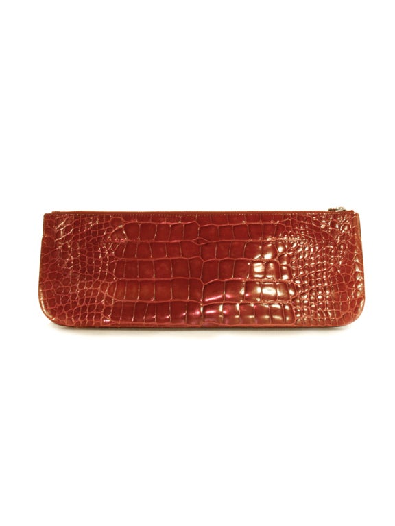 How to make the bold and stylish statement you've been dreaming of in five simple words. Prada burgundy alligator skin clutch. With an exterior of alligator leather in a vivid deep red wine color, this is an obvious choice as your new statement bag.