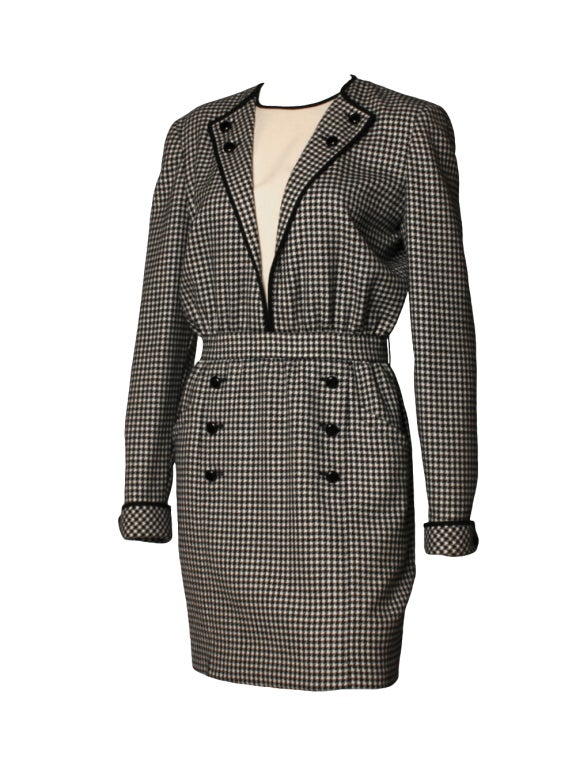 A dress worthy of Melanie Griffith in Working Girl, this 1980's Valentino Boutique houndstooth dress is intended for the woman who's on the rise.  Dress features a cream inset framed by two lapels and outlined with black piping.  On the lower half