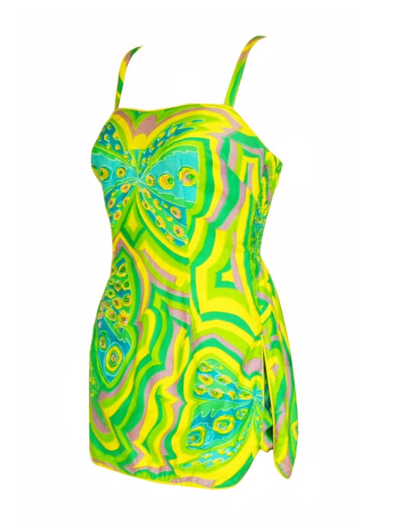 Get ready to illuminate the beach while wearing this colorful 1950s Tina Leser bathing suit. This one-piece suit is a quintessential of the 1950s with miniskirt covering, shirring detail on the sides and thick tank style straps. You will be the most