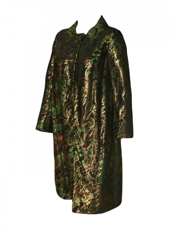 Refine your new-season style with this 1960s Pauline Trigère brocade coat.  With black, green, red and gold brocade print detailing, this evening coat also features one button on the top for closure.