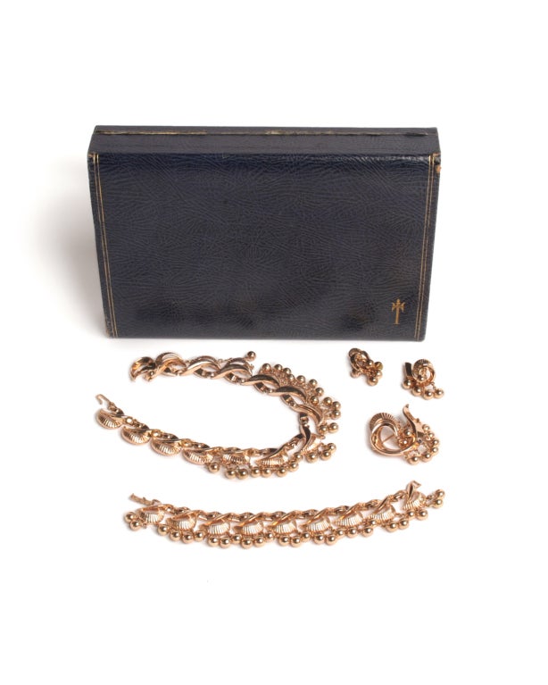 Make an oppulent addition to your evening look by investing in this Trifari four-piece gold set.  Elaboretly sculpted with gold braids and beads, this set features a pair of earrings, bracelet, brooch and necklace.  This set is a high-impact choice