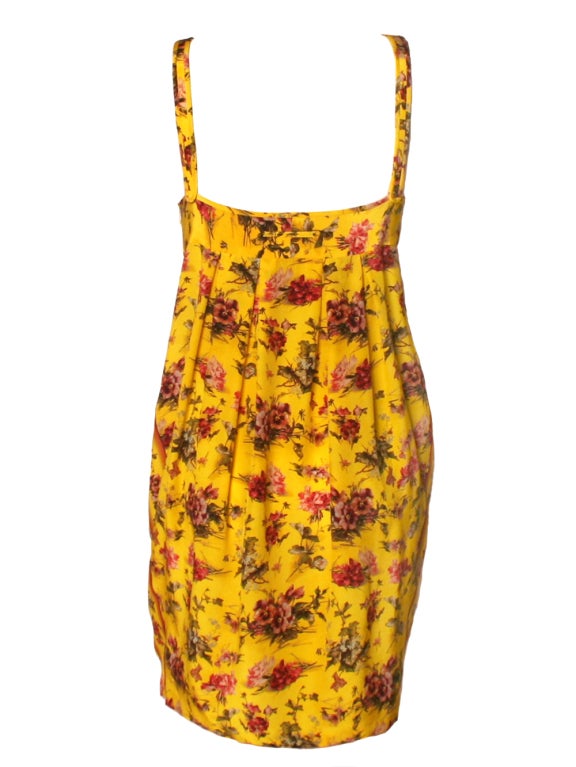 Printed on silk crepe de china, this Jean Paul Gaultier yellow floral two piece set is both feminine and chic.  This Jean Paul Gaultier features a printed silk two piece set consisting of a printed short dress with a matching batwing shrug.  The
