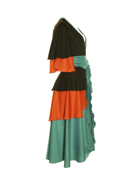 Get into a Studio 54 groove with this Giorgio di Sant' Angelo black, orange, and turquoise tiered wrap dress.  With an elegant drape, this funky wrap dress has three-quarter length butterfly sleeves layered with black and orange.  The asymmetrical