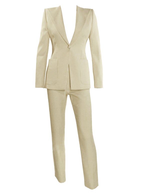 Nothing challenges the remarkable craftsmanship and delicacy of Coco Chanel and her aesthetics are clearly showcased in this magnificent cream stripe pant suit. The fully lined jacket has two front pockets, vented cuffs and single button for