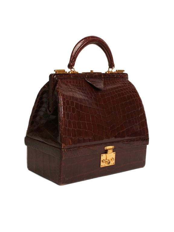 There will be no trouble getting past the velvet ropes with this spectacular vintage 1950s Hermes chocolate crocodile handbag with gold hardware in hand. It features a hidden compartment, lock and single handle. Single inner snap pocket and medium