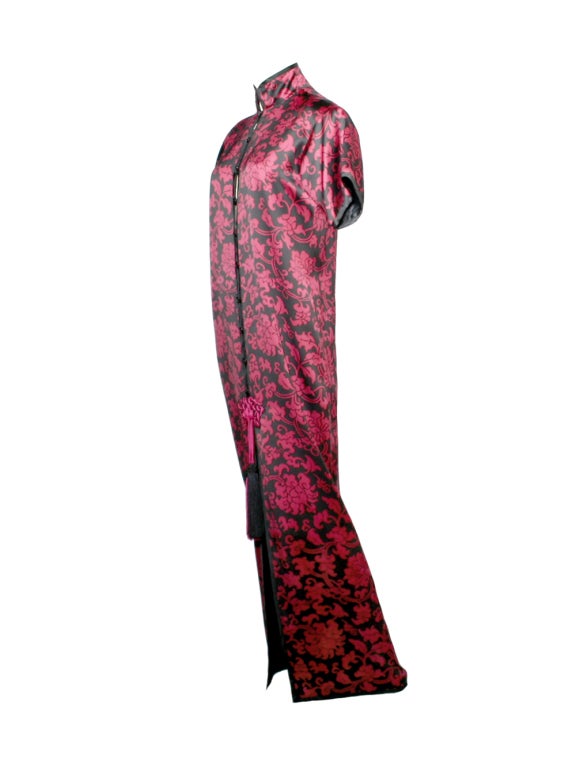 Take the Orient Express directly to first-class fashion in Yves Saint Laurent's burgundy and black, satin-blend, floral print cheongsam evening dress from the 1980s.  With a design borrowed from traditional Chinese garb, this ornate dress features a