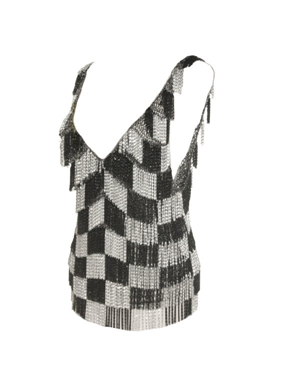 Shake, rattle, and roll in this 1970's Loris Azzaro black and silver, checker, chain tank.  Popular in the fashion world for pioneering the age of moveable clothing, Azzaro designed this ornate top in the late 197'0s with tiers of black and silver