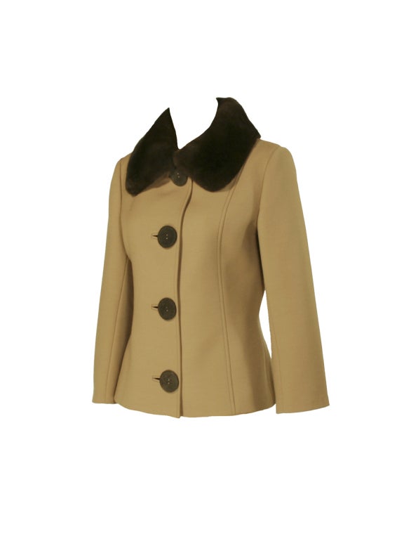 Marked with chic European sophistication, Dolce and Gabbana's taupe wool coat with brown fur collar is the favorite new addition to your fall and winter wardrobe.  A classic silhouette is created with thick taupe wool upon the waist length bodice
