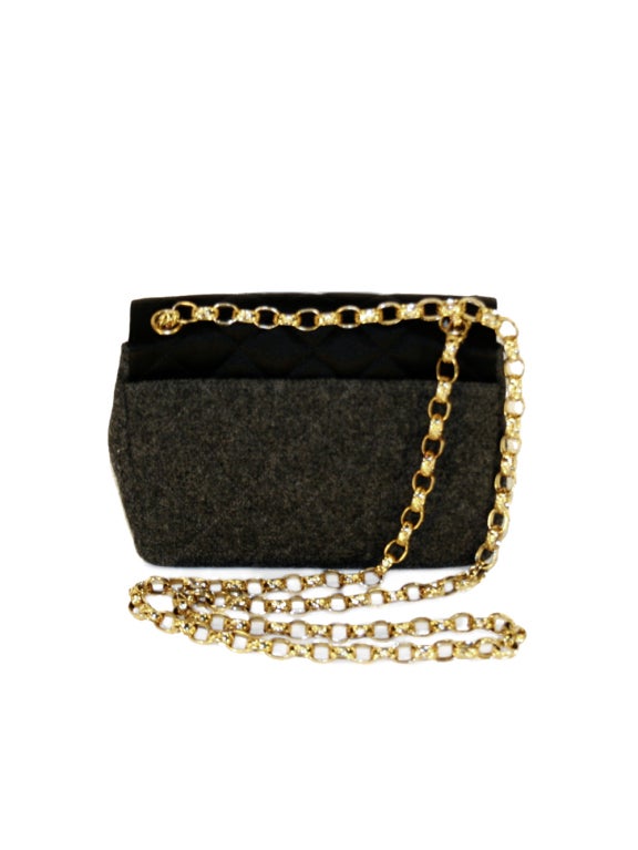 Beloved French designer Coco Chanel proves that this mini 1990's Chanel grey wool shoulder bag is a woman’s must have. Chanel’s master piece features backside flap, interior compartment and gold tone shoulder strap chain. Carry Chanel’s in style