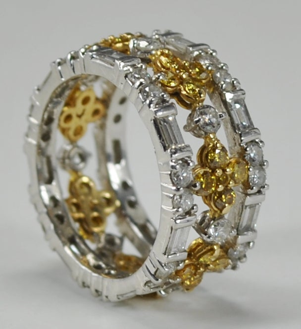 This striking band has 35 round brilliant cut natural intense yellow diamonds totaling 1.20 carats total weight. There are 14 straight cut baguette diamonds and 35 round brilliant cut diamonds.  These diamonds have an approximate GIA color and