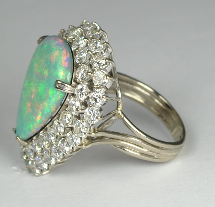 This one of a kind opal ring has a 8.81 carat Australian Opal that is on fire. The green, pinks and purple colors are fantastic.   Surrounding the Pear shaped Opal are 2 rows of fabulous diamonds.  There are 46 prong set diamonds that have an