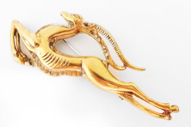 Beautiful and well-known, this signed Reja gazelle brooch pin features clear rhinestones in a gold-wash sterling silver setting.  This piece measures 3 ¾” x 1 3/8” with a turn closure, is signed Reja Sterling and is in excellent condition.