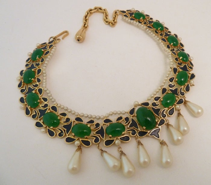 An outstanding necklace by Jomaz, this piece features green cabochon stones with faux pearls and insert black enamel accents in a gold-tone setting.  This piece measures 15” x 1 ¾” with a hook closure.  In excellent condition, this necklace is