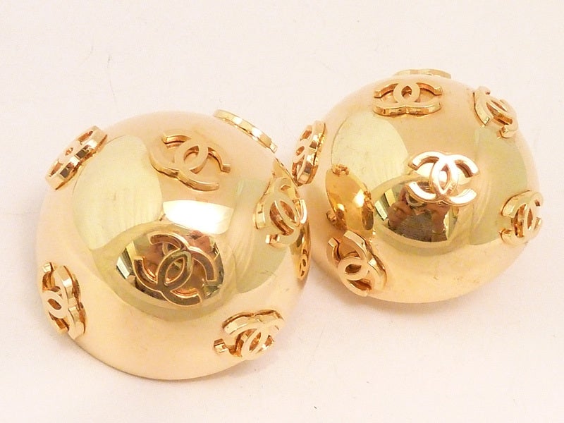 Stunning Chanel earrings with the CC logo on a domed shape gold-tone setting.  In excellent condition, these clip earrings measure 1 ¾” in diameter and are signed Chanel 27 Made in France.