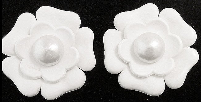 These large vintage Chanel earrings feature a camellia design with faux pearl accents in a resin and gold-tone setting.  In excellent condition, these clip earrings measure 2 3/8” in diameter and are signed Chanel in block style.
