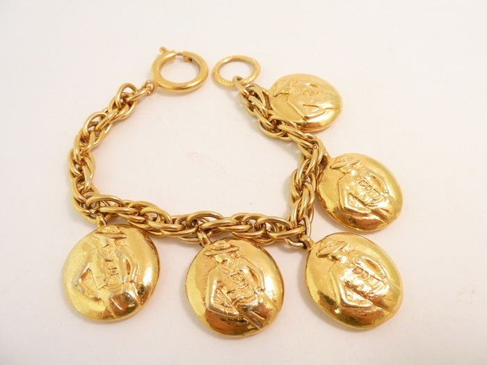 This well known Chanel bracelet has 5 charms with the stylish Coco Chanel lady on one side and the Chanel name on the other.  This multi-charm bracelet measures 8” long with a spring closure; each oval charm is 1” x 7/8”.  In excellent condition,