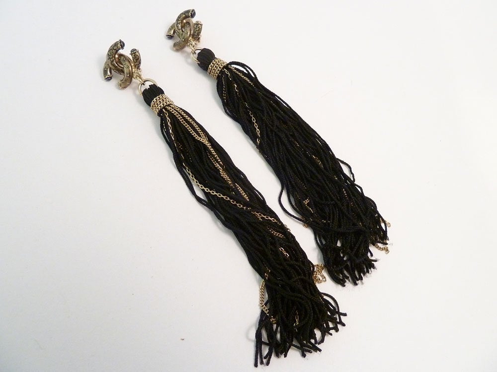 These vintage signed Chanel 10A earrings feature multiple strands of silk forming long link chain tassels, in a gold-tone setting.  In excellent condition, these long clip earrings measure 5 ½” x apx 5/8”. These elegant earrings are signed Chanel