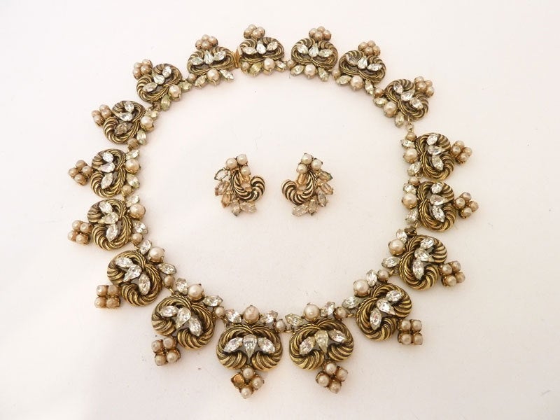 A beautiful and rare vintage 1964 Dior Germany necklace & earrings set with faux pearls and clear rhinestone accents in a gold-tone setting.  The necklace measures 16 ½” x 1 ¼” with a pressure closure.  The clip earrings are 1” x 7/8”.  In excellent