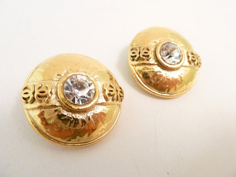 We seldom find season 23 items from the l970’s so its fun when we come across a pair of earrings.  These vintage signed Chanel earrings feature a bezel cut clear rhinestone in a gold-tone setting with the CC logo on either side.  In excellent