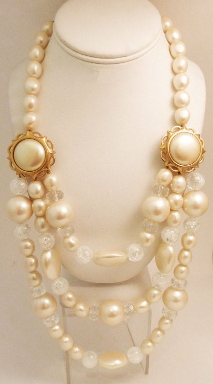 This vintage signed Yves St. Laurent necklace features two strands of faux pearls with lucite spacer beads and gold-tone joiner in a gold-tone setting.  This piece has an inside measurement of 20? with a hook closure.  A single large faux pearl is