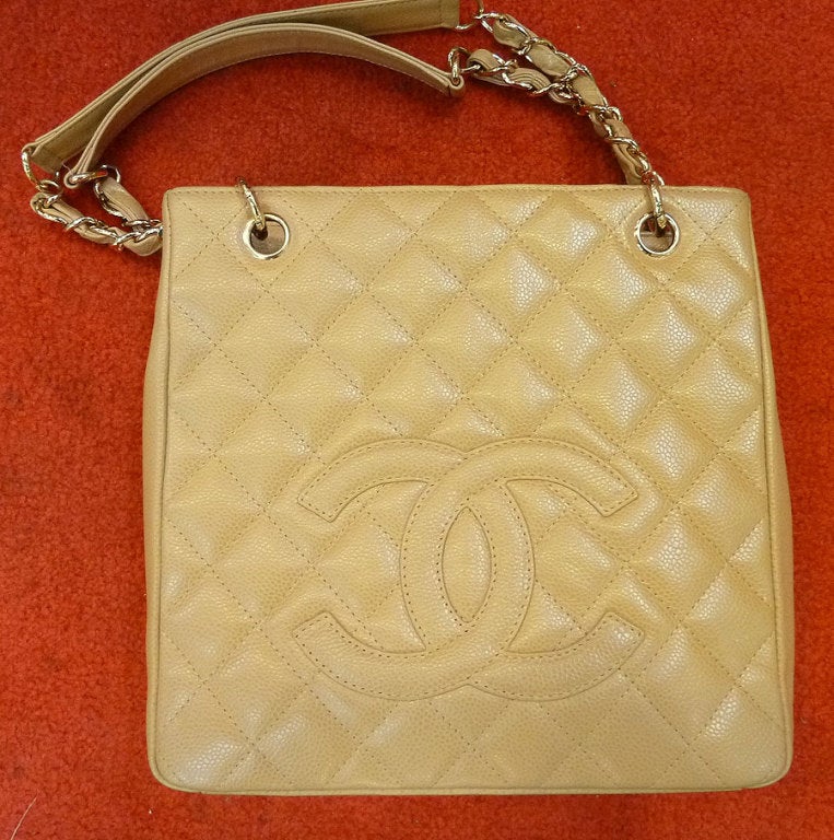 This vintage signed Chanel purse features a gold beige textured leather with gold-tone metal accents.  This purse measures 10? x 9 ½? x 3 ¾? and the double strap is 10? up from center.  Inside the purse is a slide and zipper compartment and on the