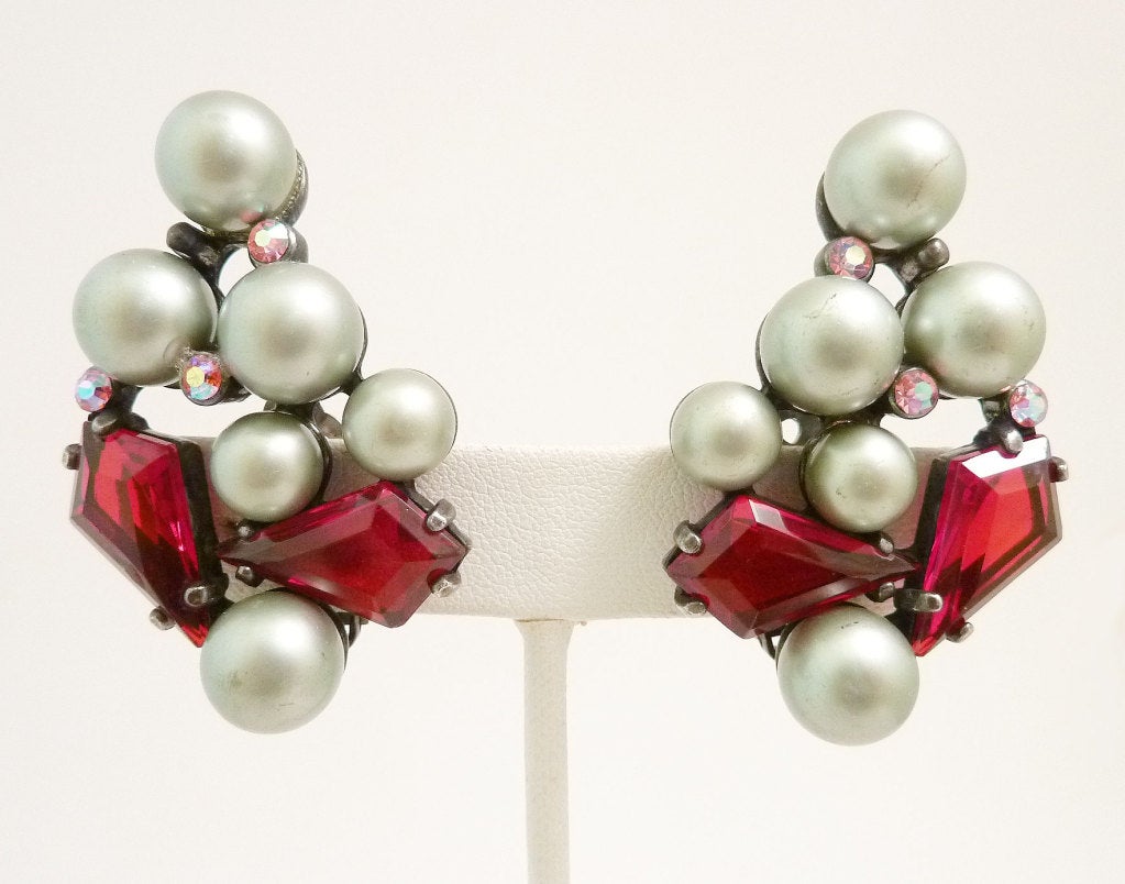 These vintage signed Schiaparelli earrings feature red and pink rhinestones with gray faux pearls in a Japanned silver-tone setting.  In excellent condition, these clip earrings measure 1 ¾? x 1 ¼? and are signed Schiaparelli.