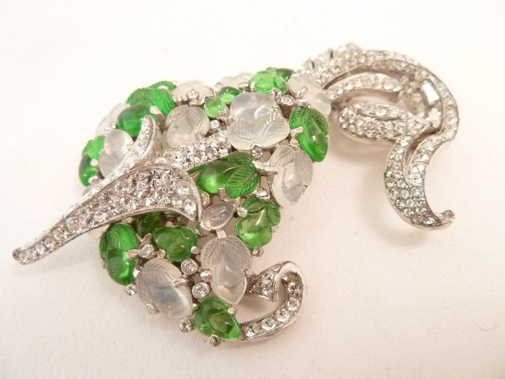 This is a collectors dream pin.  I always admired it in the jewelry books, but never owned one.  This 1930?s vintage signed Trifari fur clip-pin features green and moonstone color fruit salad stones with clear rhinestone accents in a silver-tone