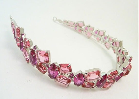 This one of a kind Robert Sorrell hair band features pink rhinestones in a silver-toe setting. It sits on top of your head like a crown of pink lights.  He also said you could wear it across your forehead for an exotic night out on the town.    This